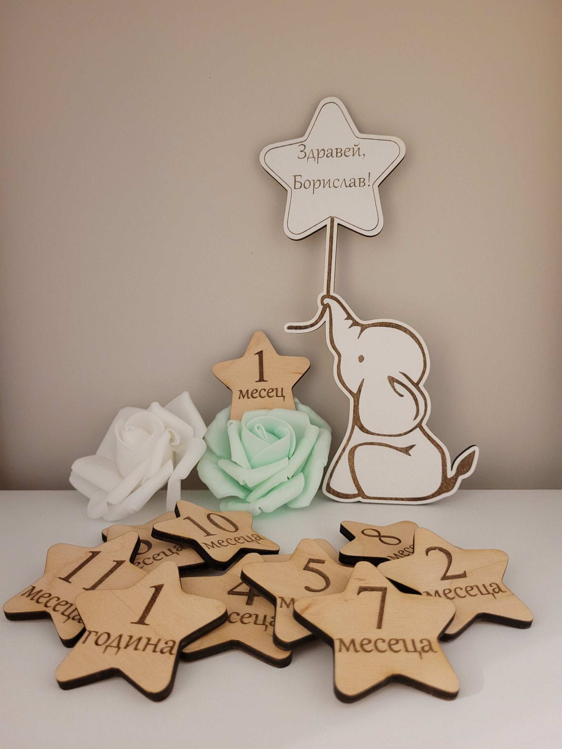 Wooden star-shaped milestone cards with numbers, text and a small elephant figure.