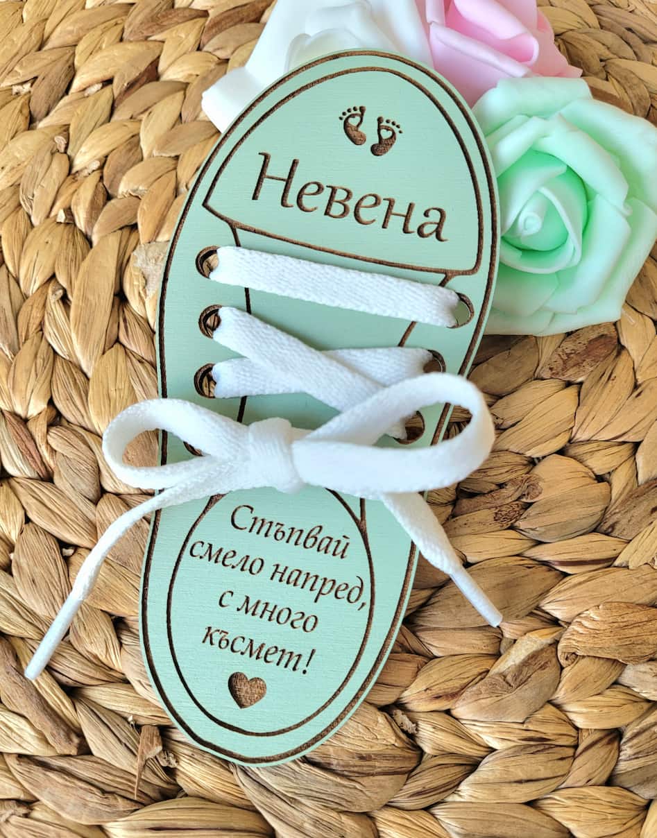 Shoe shaped tag with white laces on a woven surface with flowers