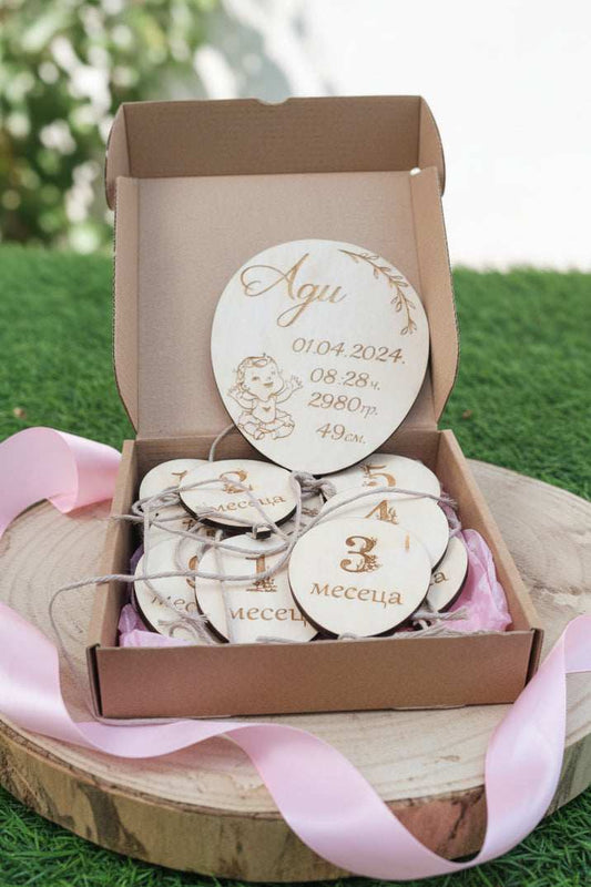 Set of wooden milestone discs with engraved text in a box on grass